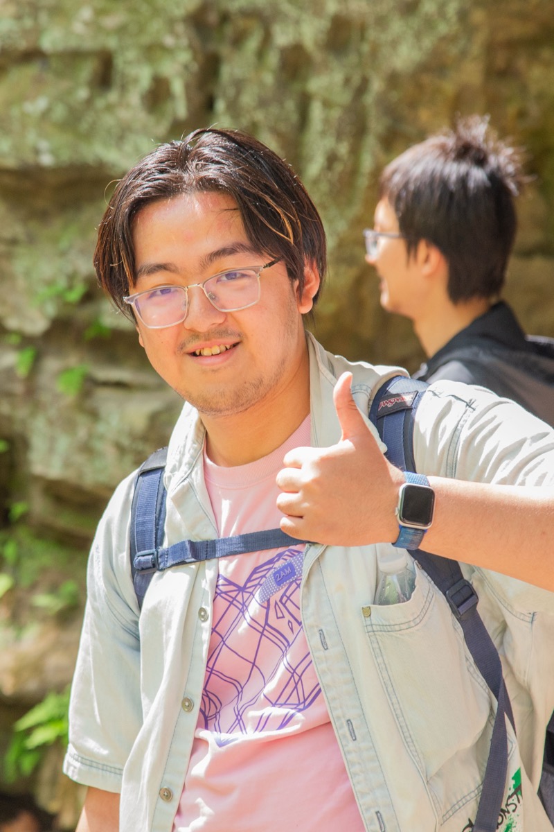Shengmiao Jin giving a thumbs up outdoors